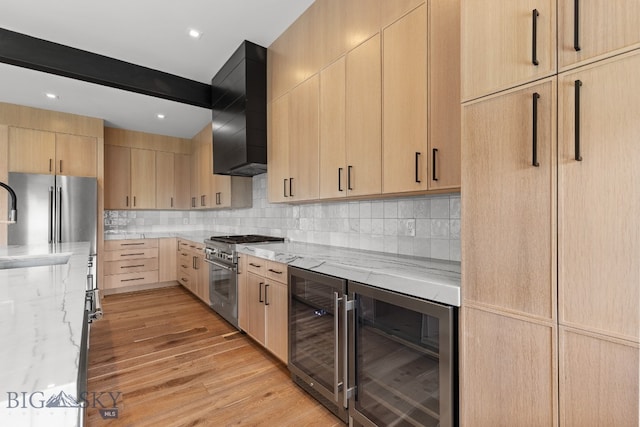 kitchen featuring appliances with stainless steel finishes, light hardwood / wood-style floors, custom exhaust hood, light brown cabinetry, and wine cooler