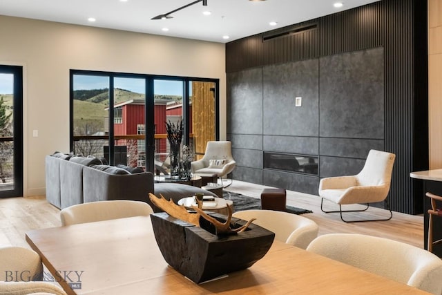 living area with recessed lighting, light wood-style flooring, and a tile fireplace