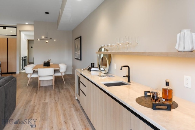 kitchen with light wood-style floors, modern cabinets, light countertops, and a sink