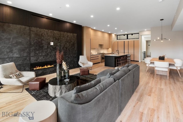 living room featuring light wood-type flooring, a fireplace, and recessed lighting