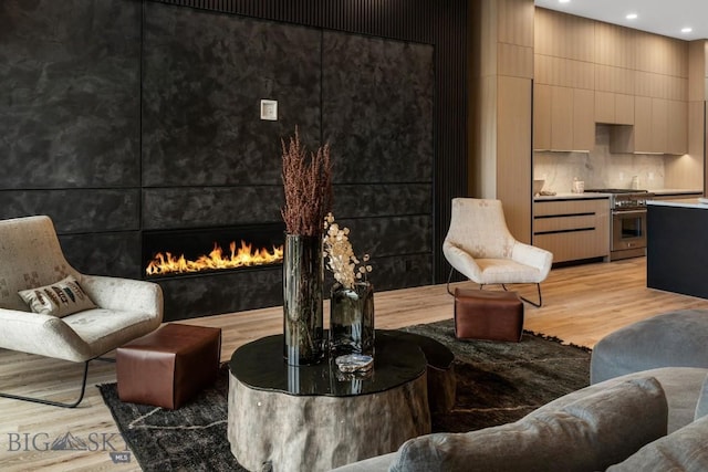 living room with light wood-style floors, a fireplace, and recessed lighting