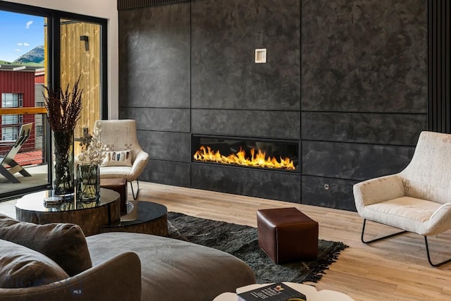 sitting room with wood finished floors and a tile fireplace