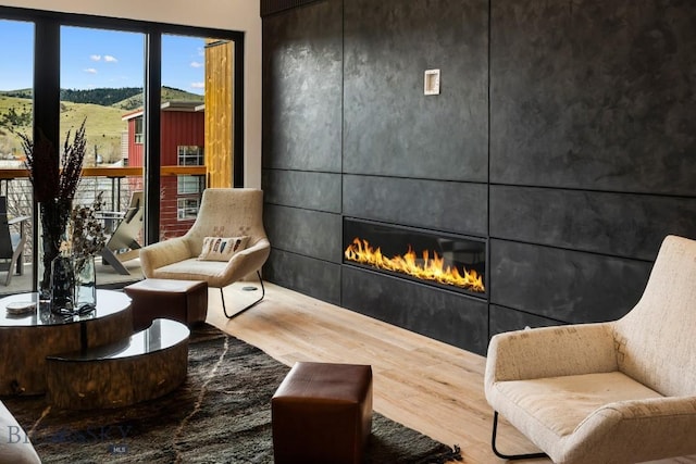 sitting room featuring a tile fireplace and wood finished floors