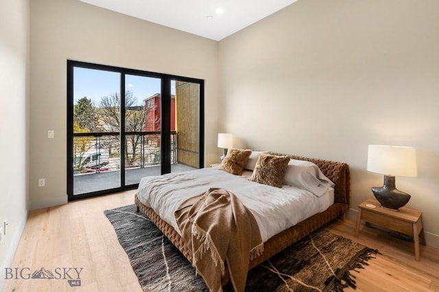 bedroom featuring access to exterior, light wood-style flooring, and baseboards