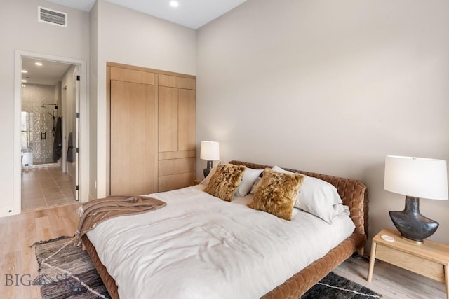 bedroom featuring light wood finished floors, a closet, visible vents, and recessed lighting