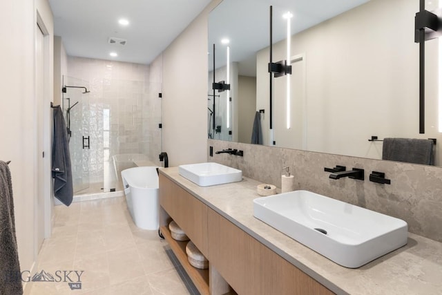 full bath featuring a freestanding tub, a stall shower, a sink, and visible vents