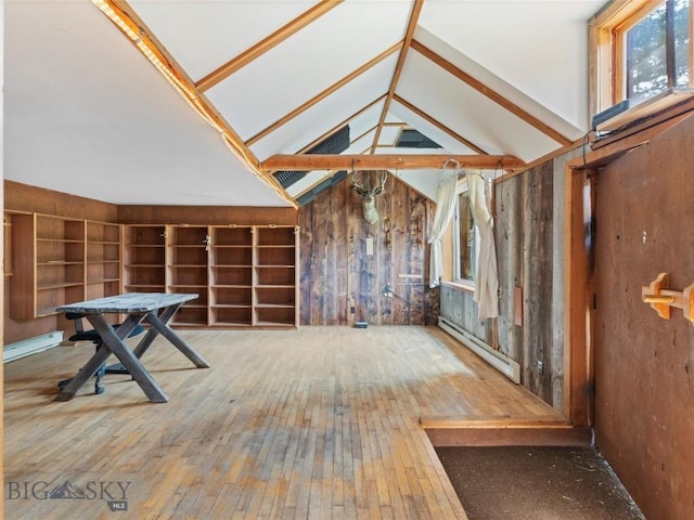 misc room featuring baseboard heating, lofted ceiling, built in shelves, and hardwood / wood-style floors