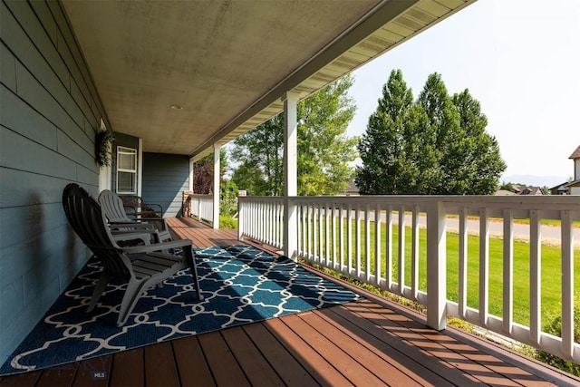 wooden deck with covered porch and a yard