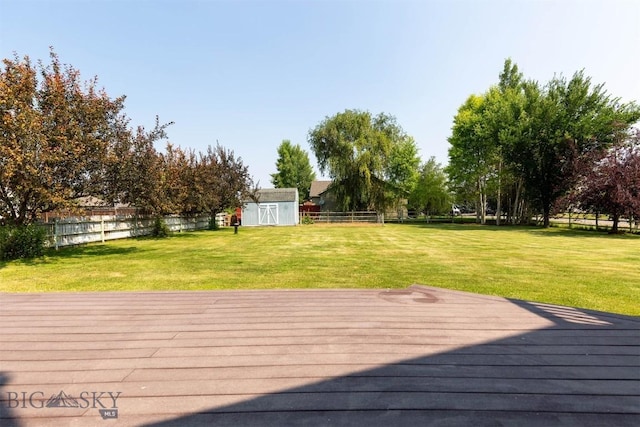 deck with a yard and a shed