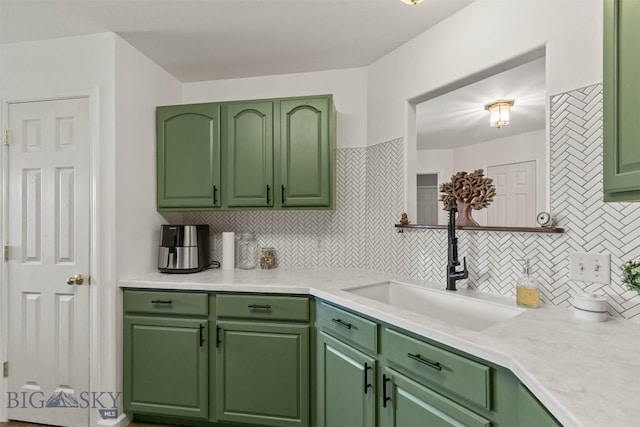 kitchen with sink, backsplash, and green cabinets