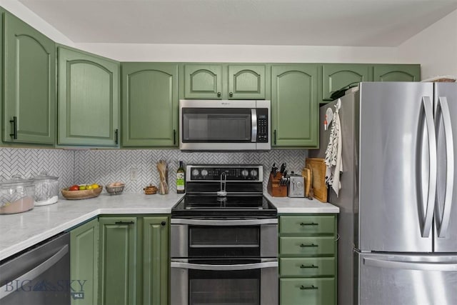 kitchen with green cabinets, stainless steel appliances, and tasteful backsplash