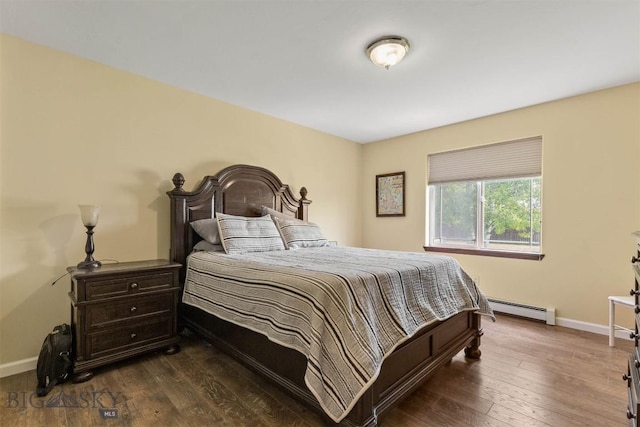 bedroom featuring a baseboard heating unit and dark hardwood / wood-style floors