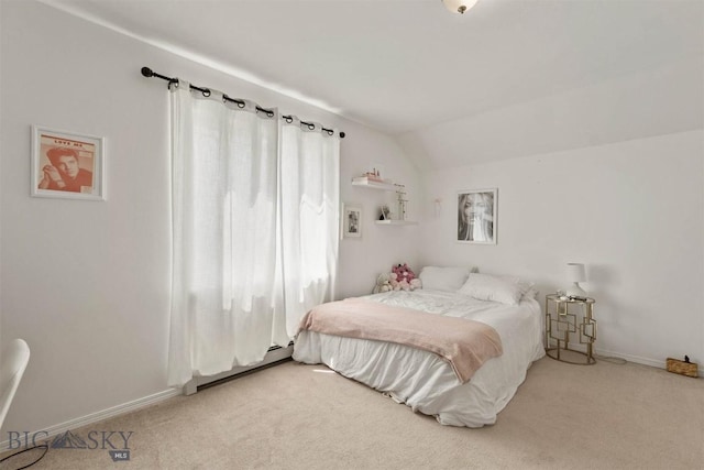 carpeted bedroom featuring vaulted ceiling and baseboard heating