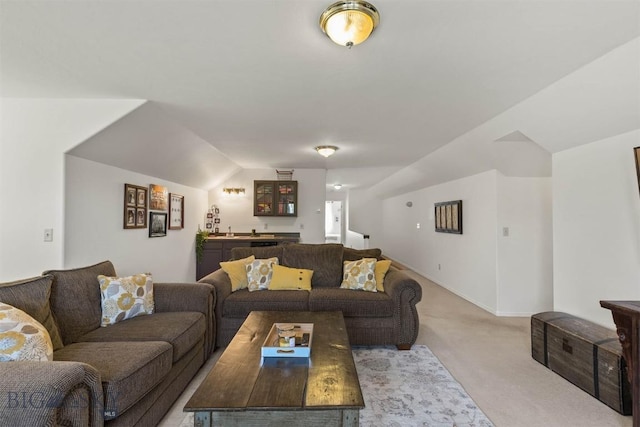 carpeted living room with wet bar and lofted ceiling