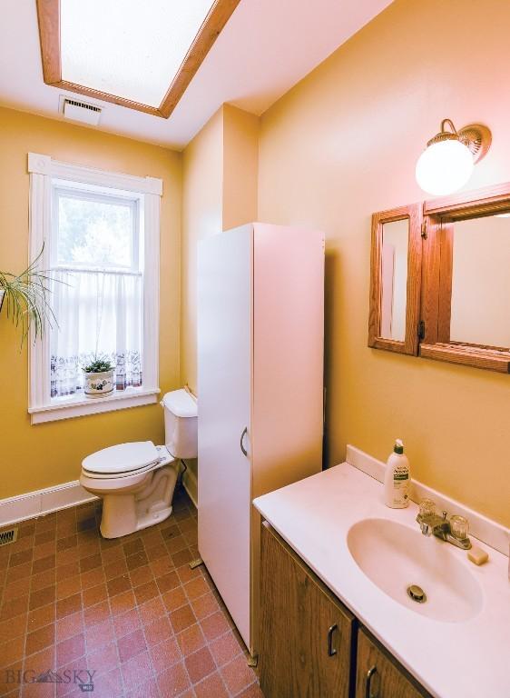 113 E Poppleton, Sheridan, MT 59749 - bathroom with toilet, vanity, and baseboards