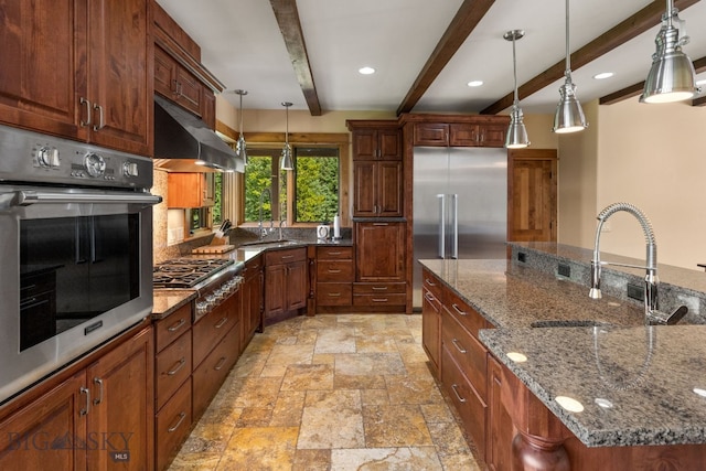 kitchen featuring dark stone countertops, pendant lighting, beamed ceiling, and stainless steel appliances