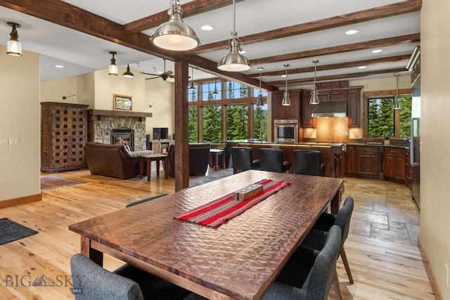 220 Watershed Rd, Big Sky, MT 59716 - dining space featuring beam ceiling, ceiling fan, a stone fireplace, recessed lighting, and baseboards