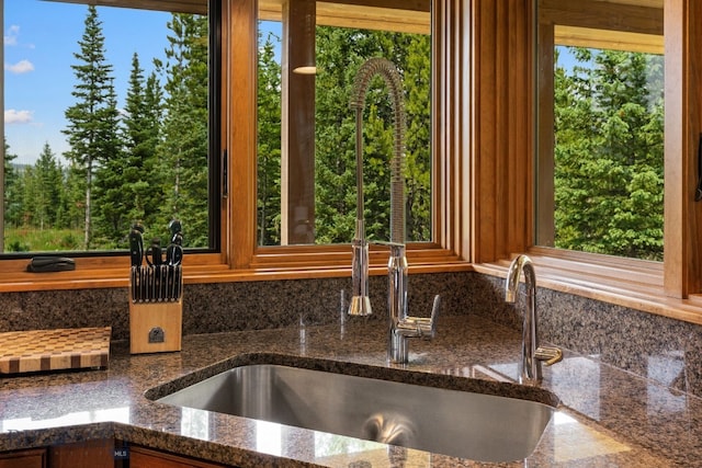 220 Watershed Rd, Big Sky, MT 59716 - kitchen view of backsplash, a sink, and dark stone counters