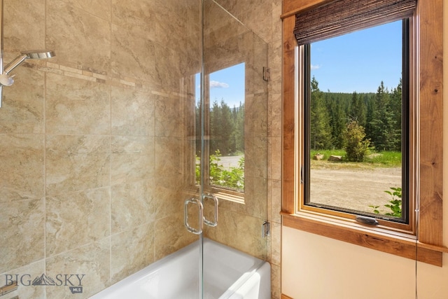 bathroom with bath / shower combo with glass door and a healthy amount of sunlight