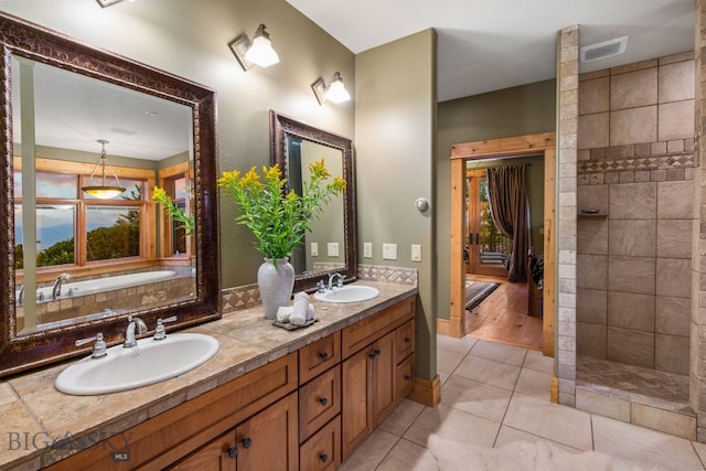 bathroom with tile patterned flooring, independent shower and bath, and vanity