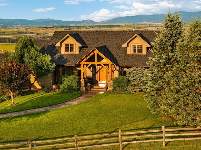 view of front of property with a mountain view, a front yard, and a rural view