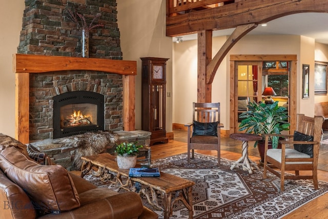 living room featuring a high ceiling, a fireplace, and hardwood / wood-style floors