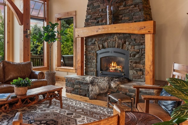 interior space featuring a stone fireplace, hardwood / wood-style flooring, and a high ceiling