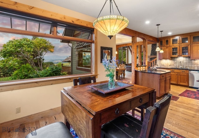 dining area with an inviting chandelier, light hardwood / wood-style flooring, and sink