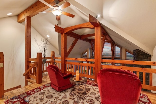 sitting room featuring ceiling fan, vaulted ceiling with beams, and light wood-type flooring