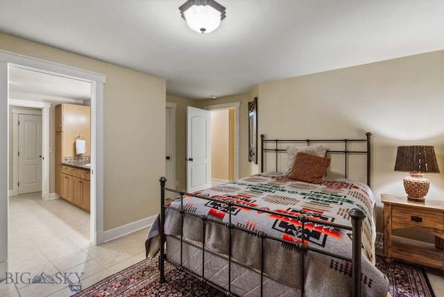 bedroom featuring ensuite bath and light tile patterned floors