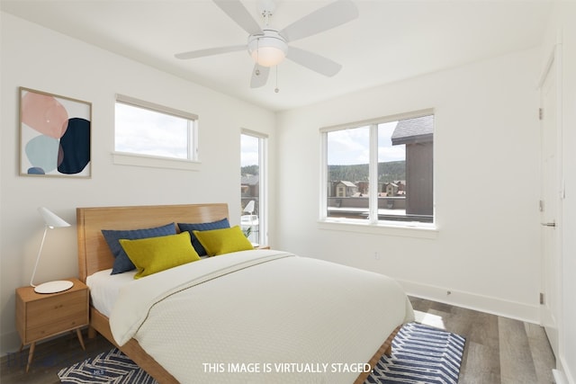 bedroom with dark hardwood / wood-style flooring and ceiling fan