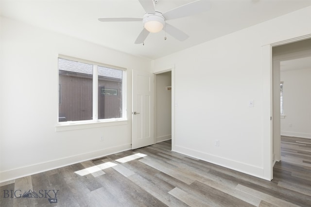 unfurnished room featuring hardwood / wood-style floors, a wealth of natural light, and ceiling fan