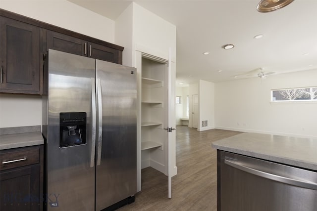 kitchen featuring dark brown cabinetry, ceiling fan, hardwood / wood-style floors, and stainless steel appliances