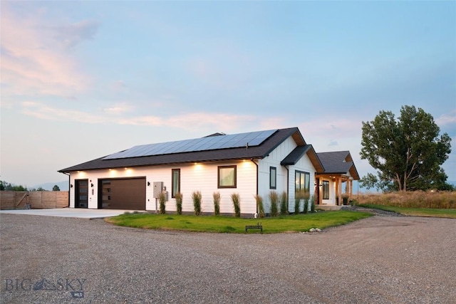 view of front facade featuring a garage and solar panels