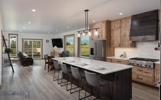 kitchen featuring decorative light fixtures, backsplash, custom exhaust hood, a center island, and stainless steel appliances