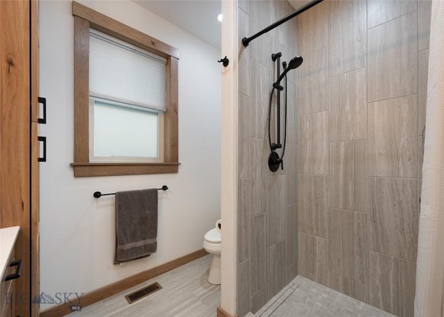 bathroom with toilet and a shower with shower curtain