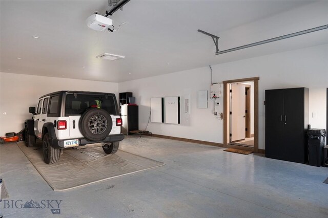 garage with a garage door opener and electric panel