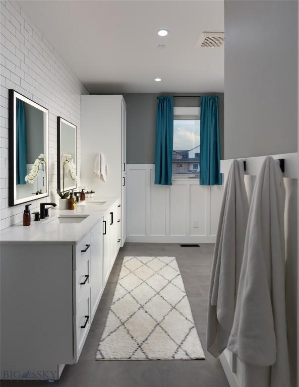 bathroom with vanity and brick wall