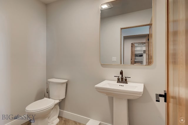 bathroom featuring hardwood / wood-style floors and toilet