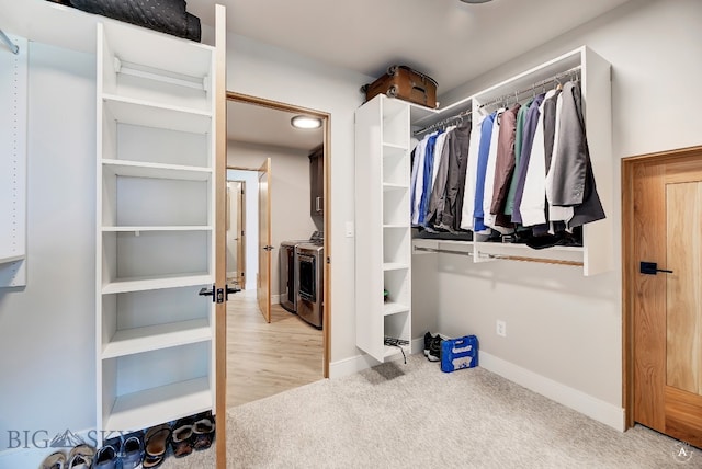 spacious closet with washing machine and dryer and light colored carpet