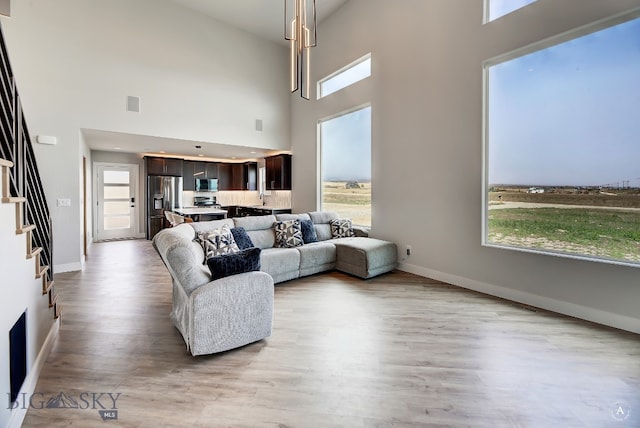 living room with light hardwood / wood-style floors and a high ceiling