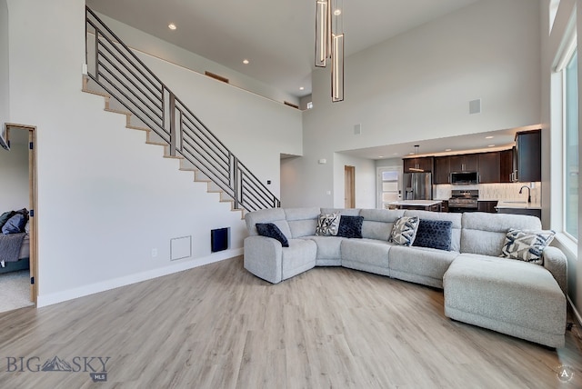 living room with light hardwood / wood-style flooring and a high ceiling