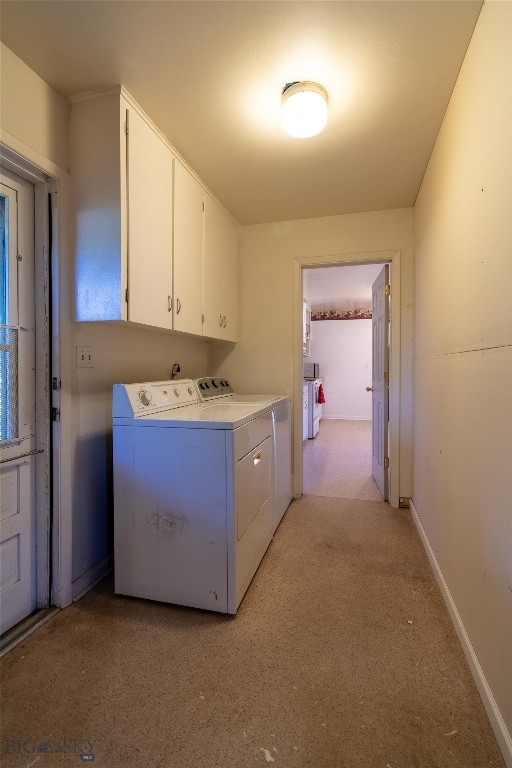 laundry area featuring light carpet, cabinets, and independent washer and dryer