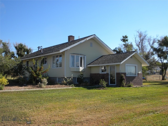 rear view of property featuring a yard and a chimney