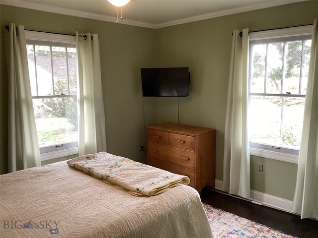 bedroom with crown molding, baseboards, and dark wood-style flooring