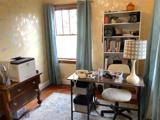 home office featuring wallpapered walls, light wood-style flooring, and baseboards