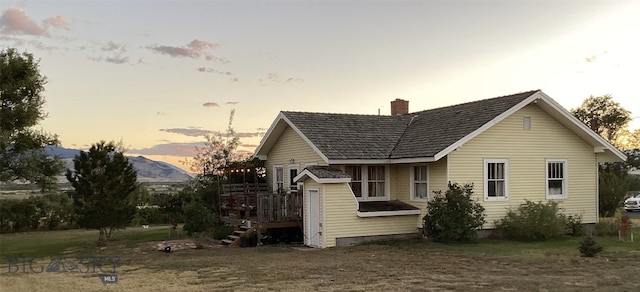 back of property with a lawn and a chimney