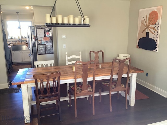 dining area with baseboards and dark wood-style flooring