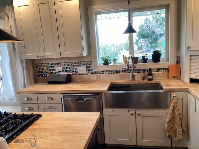 kitchen with dishwasher, tasteful backsplash, a sink, and decorative light fixtures