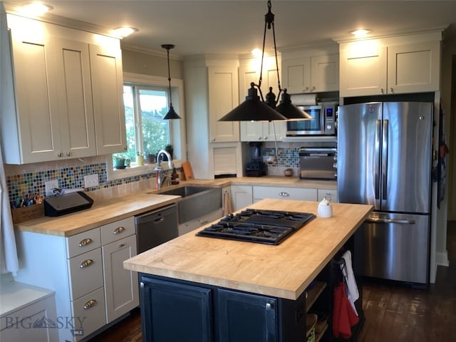 kitchen with a center island, hanging light fixtures, wood counters, and black appliances